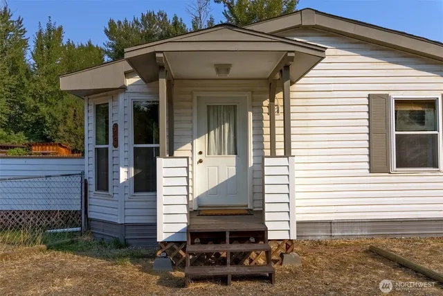 a view of a white house with large windows and a yard