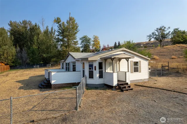a white house that has a tree in front of it