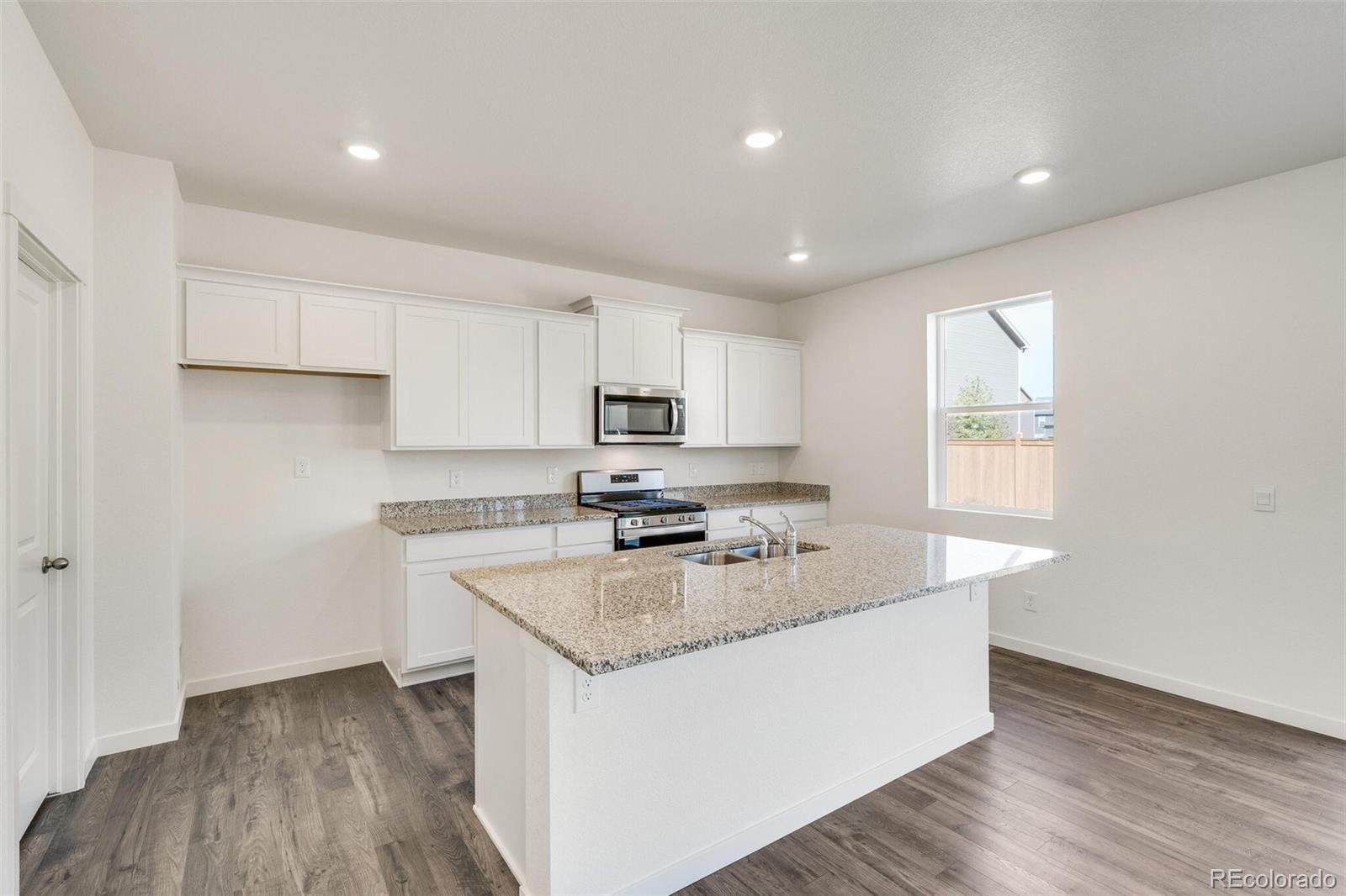 3058 Belleville Ridge Road Elizabeth, CO 80107 - Photo 11 of 31 a large kitchen with stainless steel appliances granite countertop a stove a sink and a refrigerator