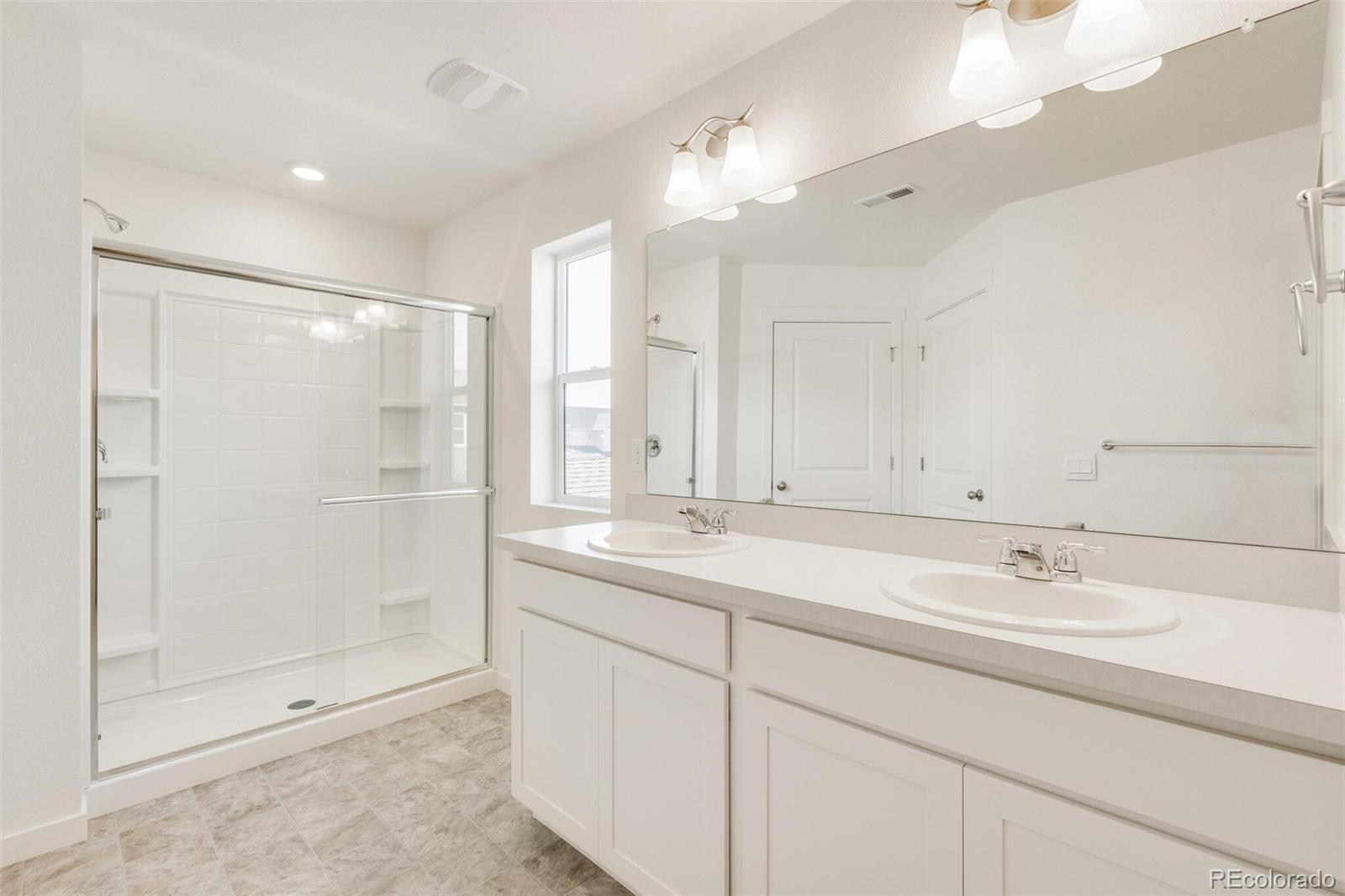 3058 Belleville Ridge Road Elizabeth, CO 80107 - Photo 22 of 31 a bathroom with double sink and a mirror