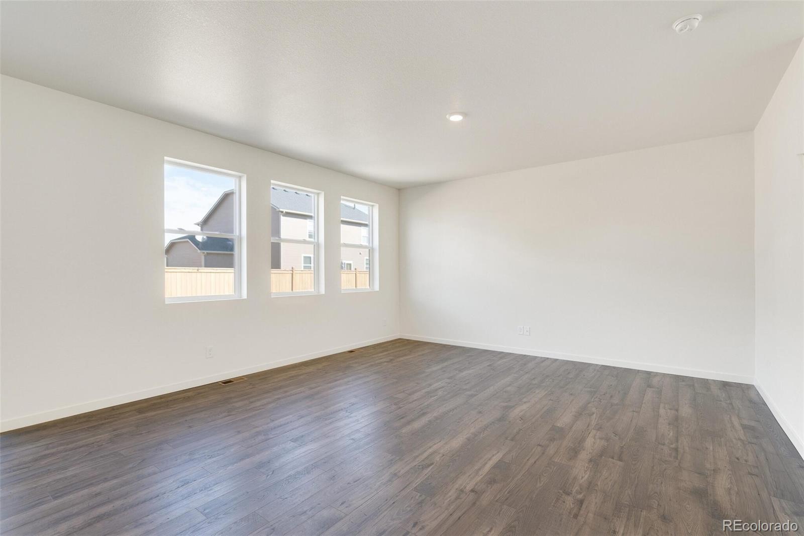 3058 Belleville Ridge Road Elizabeth, CO 80107 - Photo 8 of 31 an empty room with wooden floor and windows