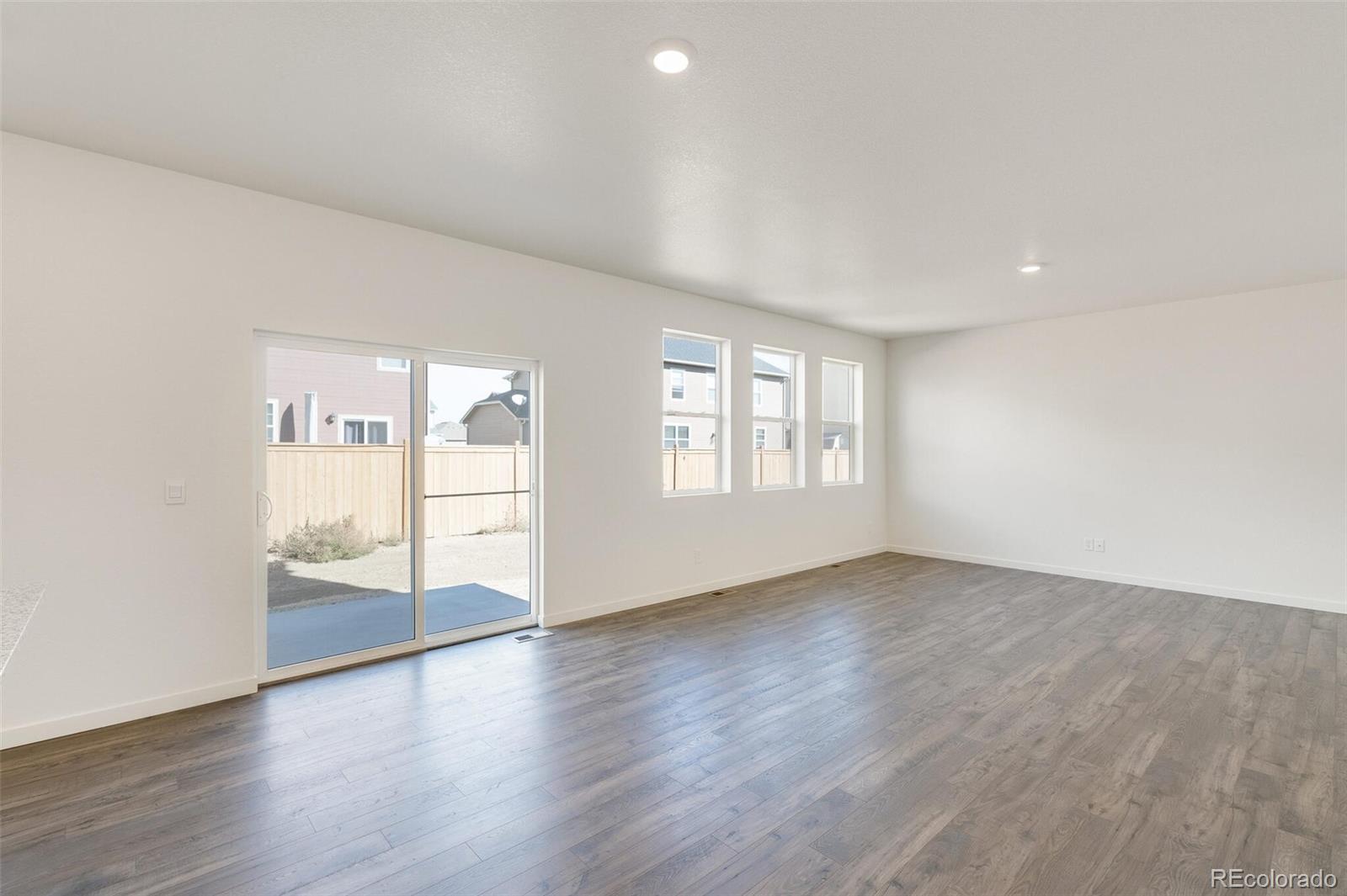 3058 Belleville Ridge Road Elizabeth, CO 80107 - Photo 9 of 31 an empty room with wooden floor and windows