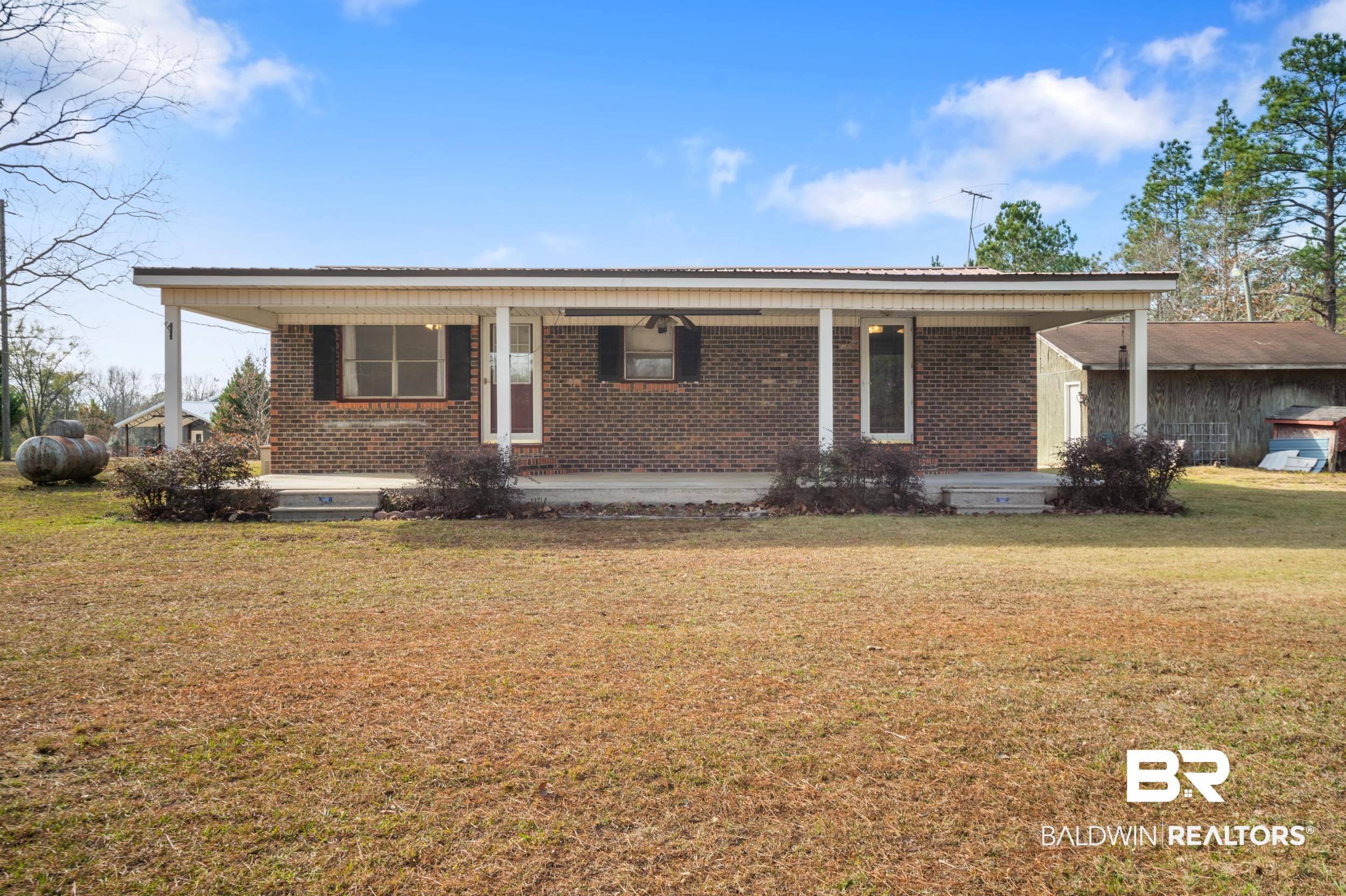 57623 Mary Hadley Road Perdido, AL 36562 - Photo 2 of 34 Ranch-style home with covered porch, brick siding, and a front yard