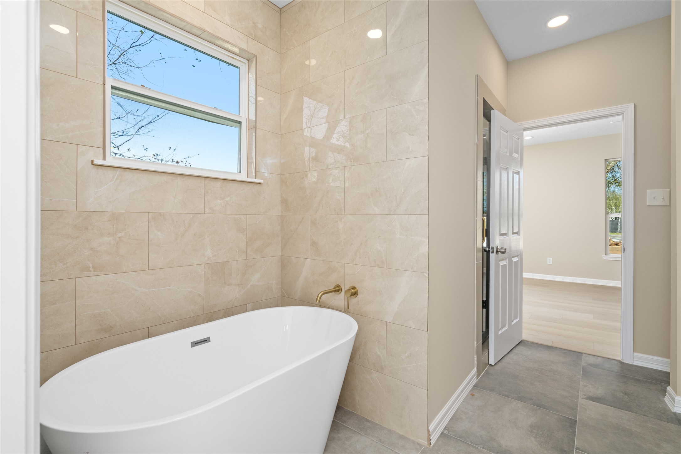 4654 North Teague Street Rosharon, TX 77583 - Photo 32 of 46 Stunning freestanding tub
framed by sleek tile work—
perfect for relaxing evenings.
Bright, airy design
complements modern
finishes.