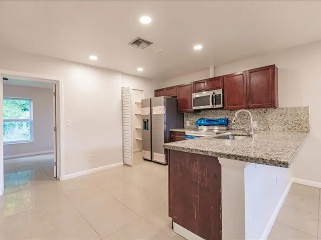 a kitchen with stainless steel appliances granite countertop a sink stove and refrigerator