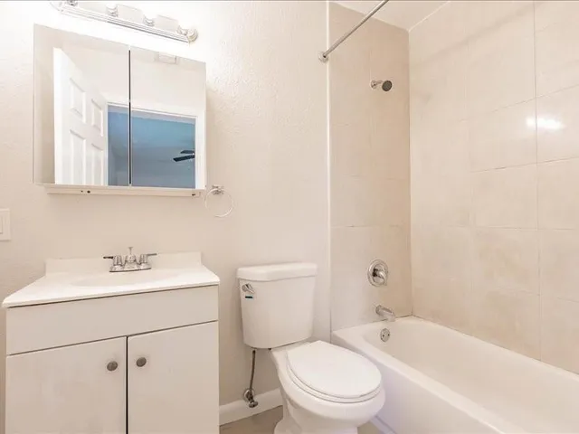 a bathroom with a sink toilet vanity and bathtub