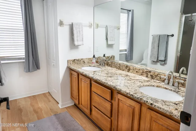 a en suite bathroom with a granite countertop sink and a mirror