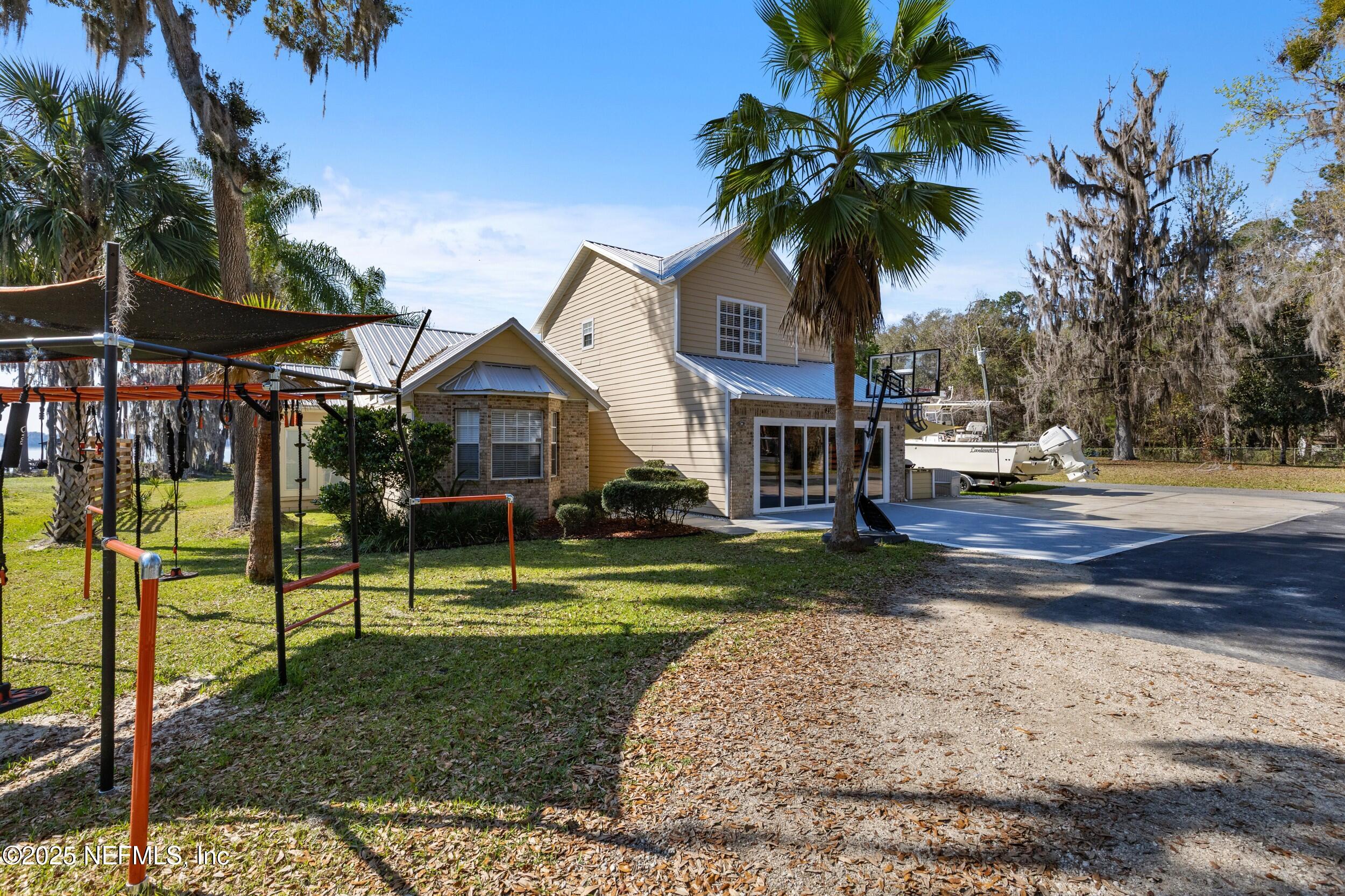 2380 Southeast 43rd Street Keystone Heights, FL 32656 - Photo 44 of 61 a palm tree sitting in front of a house with a big yard
