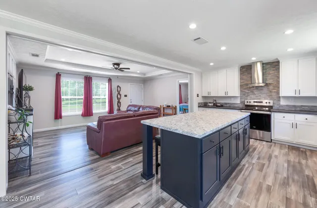 a kitchen with a stove a sink dishwasher and a refrigerator with wooden floor