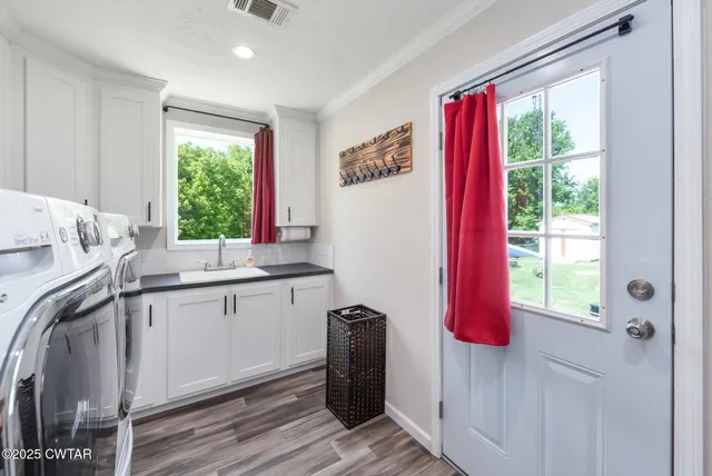 a kitchen with a window a sink and a wooden floor