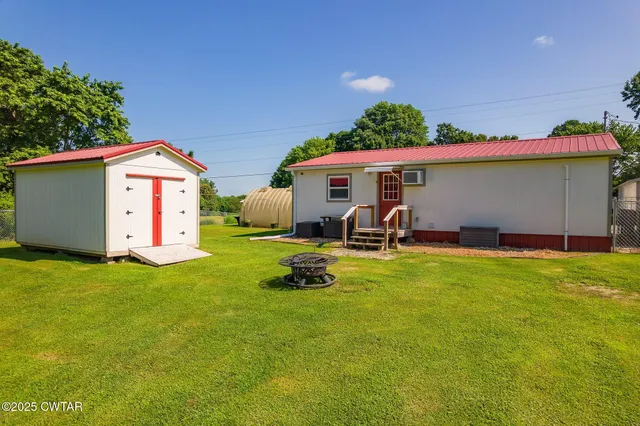a backyard of a house with table and chairs