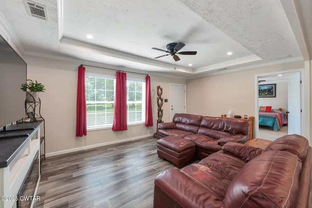 a living room with furniture a chandelier and a wooden floor