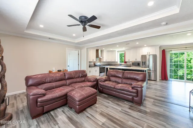 a living room with furniture and a view of kitchen