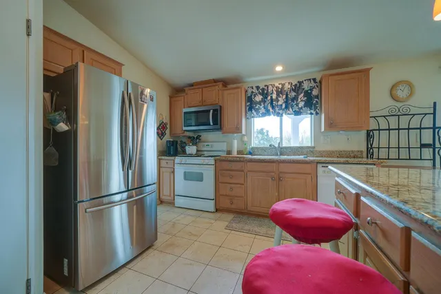 a kitchen with stainless steel appliances granite countertop a refrigerator sink and stove
