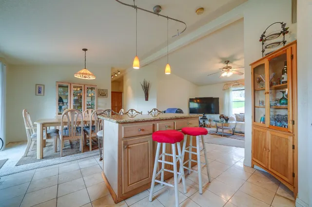 a kitchen with stainless steel appliances kitchen island granite countertop dining table chairs and a granite counter top