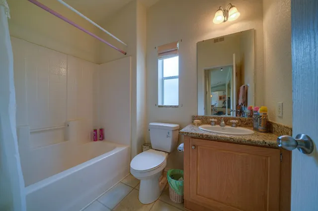 a bathroom with a granite countertop sink a toilet and bathtub