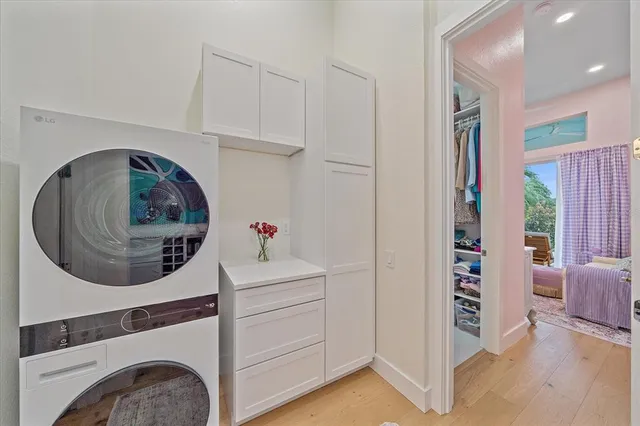 a large white kitchen with a stove a sink dishwasher and a refrigerator with wooden floor