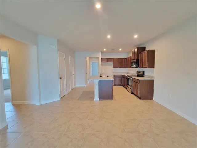 a kitchen with stainless steel appliances granite countertop a sink a stove and a refrigerator