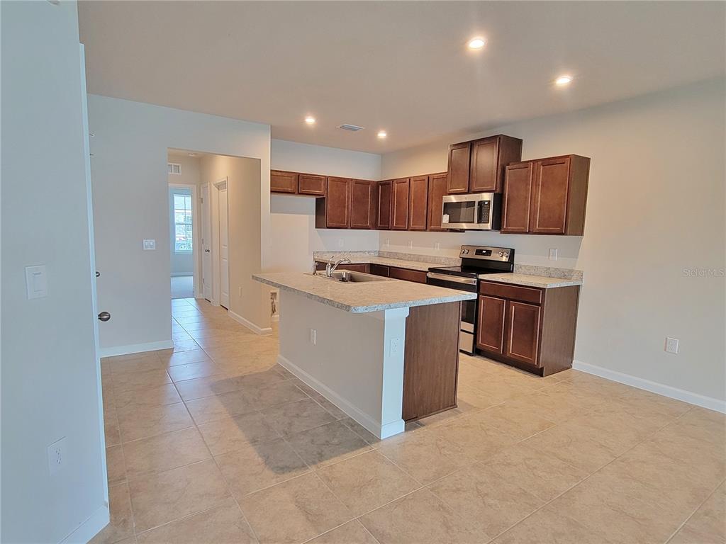 18008 Turning Leaf Circle Land O Lakes, FL 34638 - Photo 17 of 54 a kitchen with stainless steel appliances granite countertop a stove a sink and a refrigerator