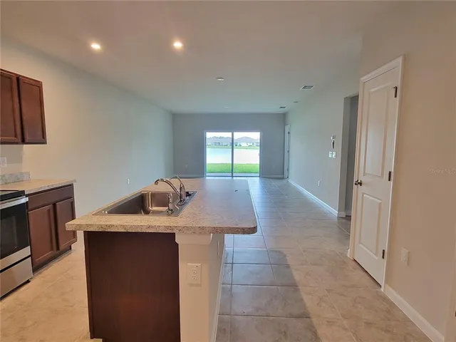 a kitchen with sink a refrigerator and microwave