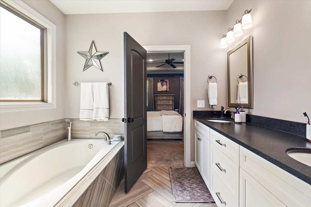 525 Piccadilly Drive Murfreesboro, TN 37128 - Photo 21 of 44 a bathroom with a granite countertop tub sink a mirror and a bathtub