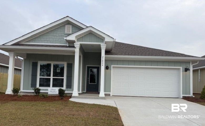 21844 Aleutian Avenue Foley, AL 36535 - Photo 1 of 40 View of front of house featuring board and batten siding, a shingled roof, a porch, and a garage