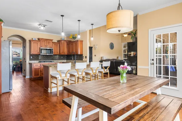an open kitchen with dining table and wooden floor