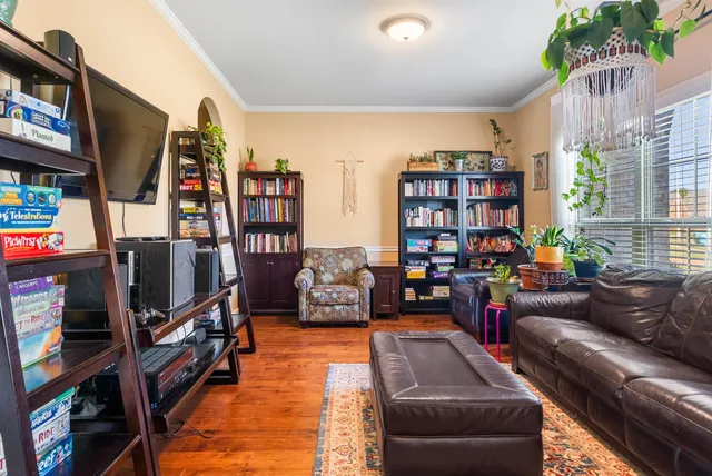 a living room with furniture a flat screen tv and a book shelf