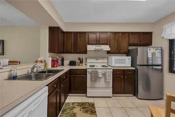 a kitchen with a sink a refrigerator and cabinets