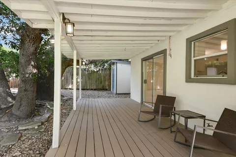 a view of a patio with table and chairs with wooden floor and fence