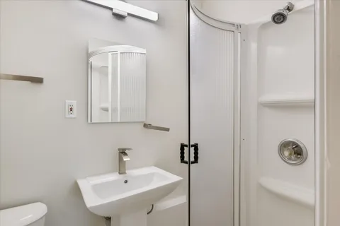 a bathroom with a sink a toilet and a mirror
