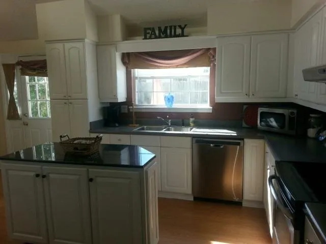a kitchen with granite countertop a sink and a stove