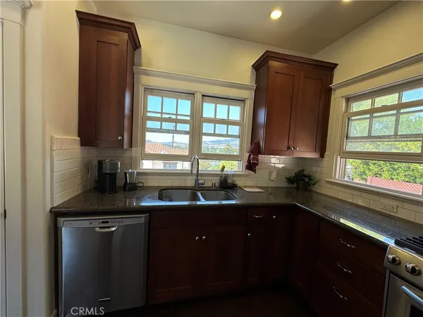 a kitchen with a sink a window and cabinets