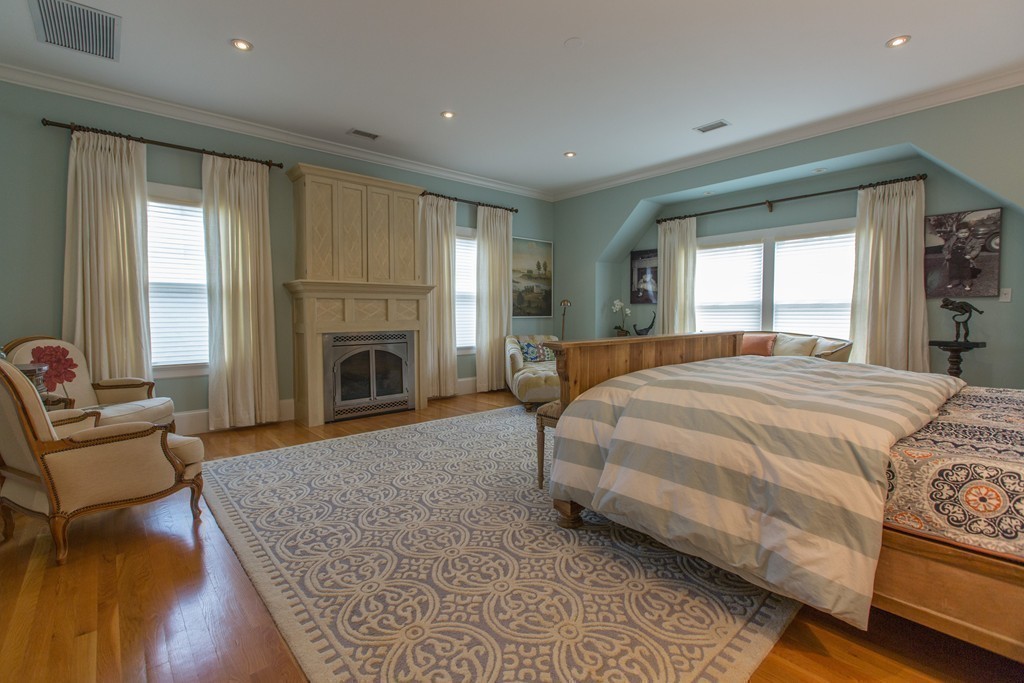 350 Musketaquid Road Concord, MA 01742 - Photo 16 of 24 a spacious bedroom with a balcony a bed and a fireplace