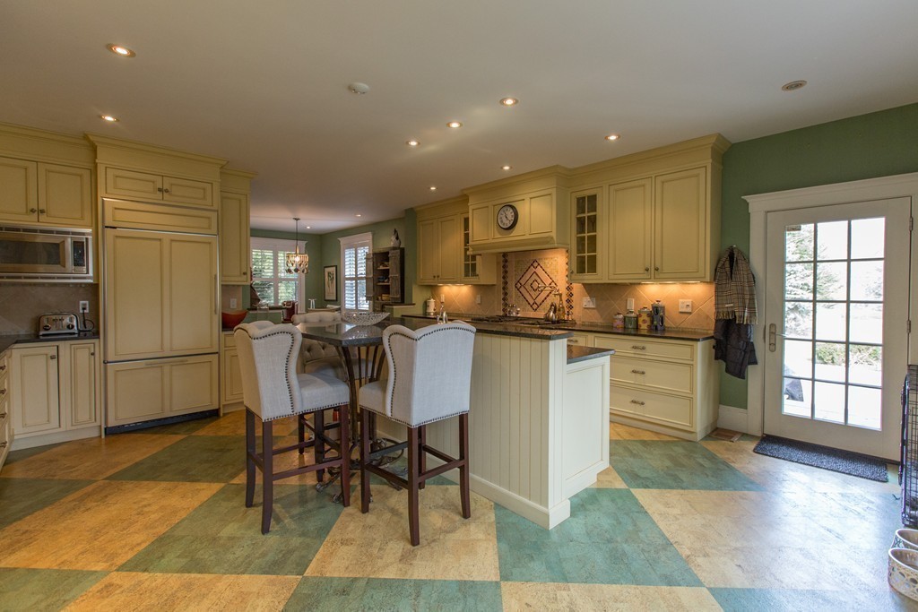 350 Musketaquid Road Concord, MA 01742 - Photo 9 of 24 a kitchen with stainless steel appliances kitchen island granite countertop dining table chairs and a refrigerator