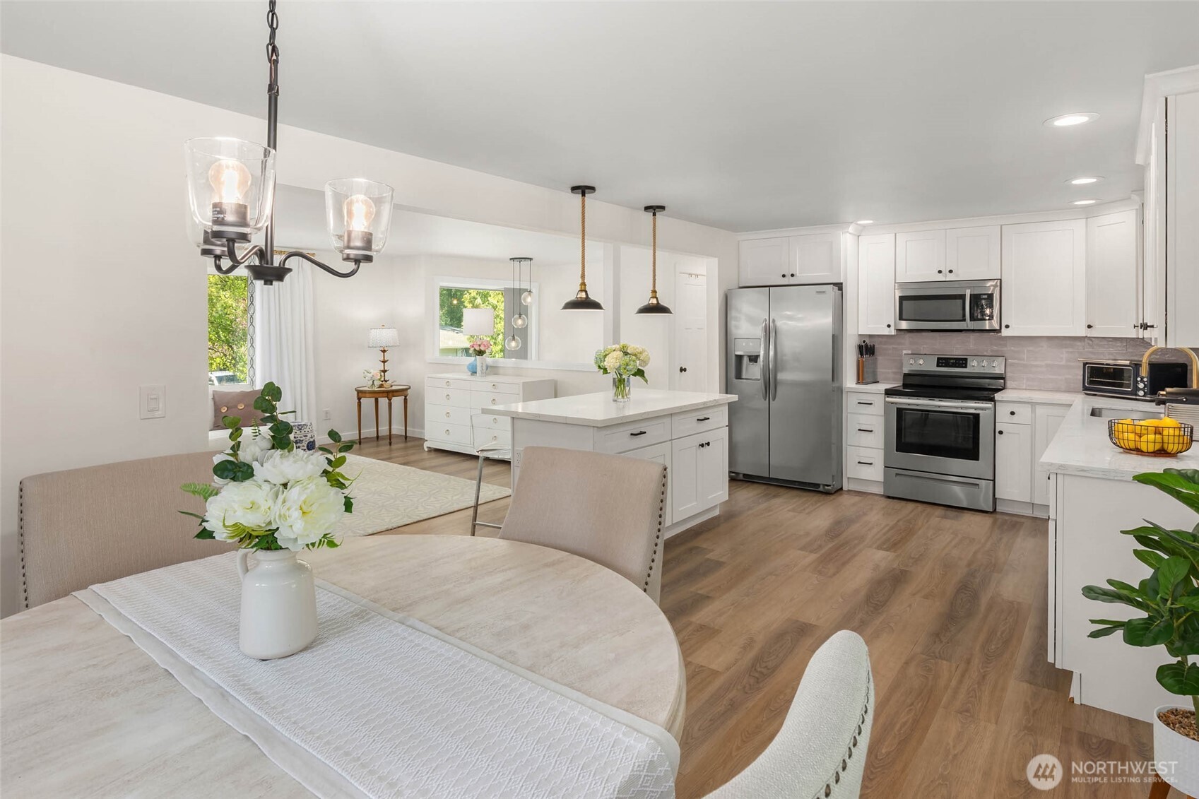 11019 23rd Drive Southeast Everett, WA 98208 - Photo 14 of 35 a kitchen with stainless steel appliances kitchen island granite countertop a sink a stove refrigerator and a dining table with wooden floor