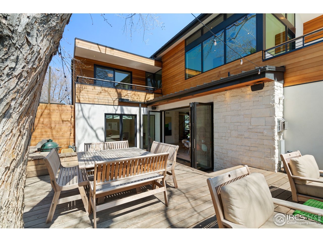 550 Iris Avenue Boulder, CO 80304 - Photo 34 of 39 a view of a patio with a table and chairs and floor to ceiling window next to a yard