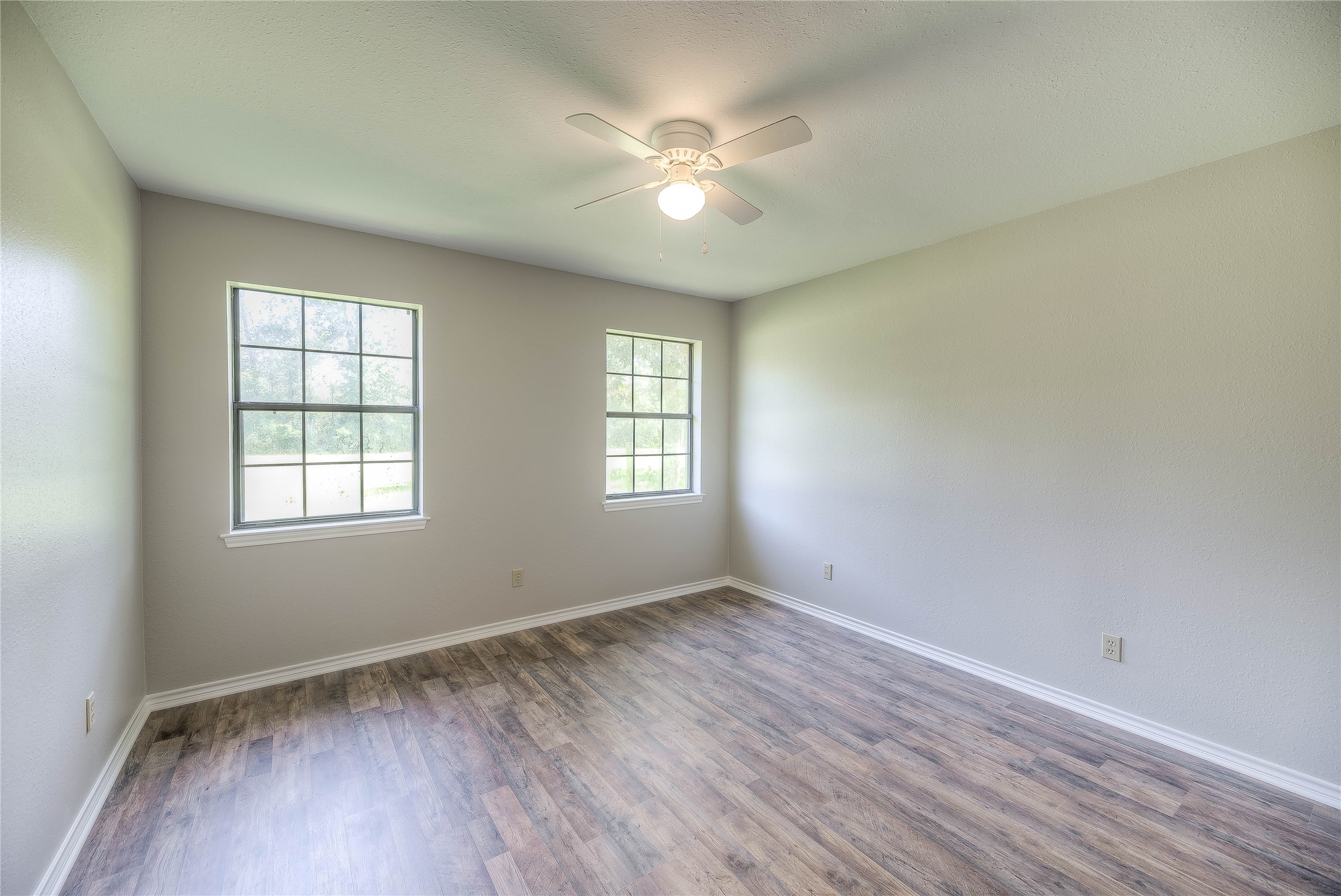 438 Bird Road Livingston, TX 77351 - Photo 13 of 37 an empty room with wooden floor and windows