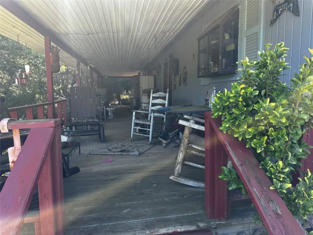 a view of a patio with table and chairs with wooden floor and plants