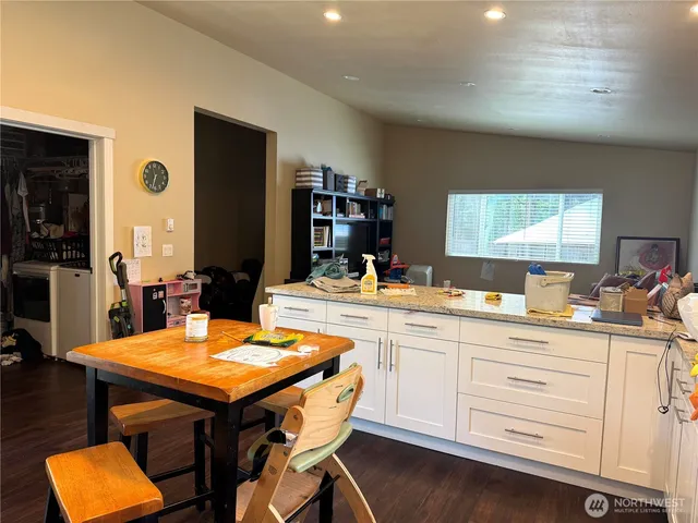 a kitchen with stainless steel appliances cabinets wooden floor and dining table