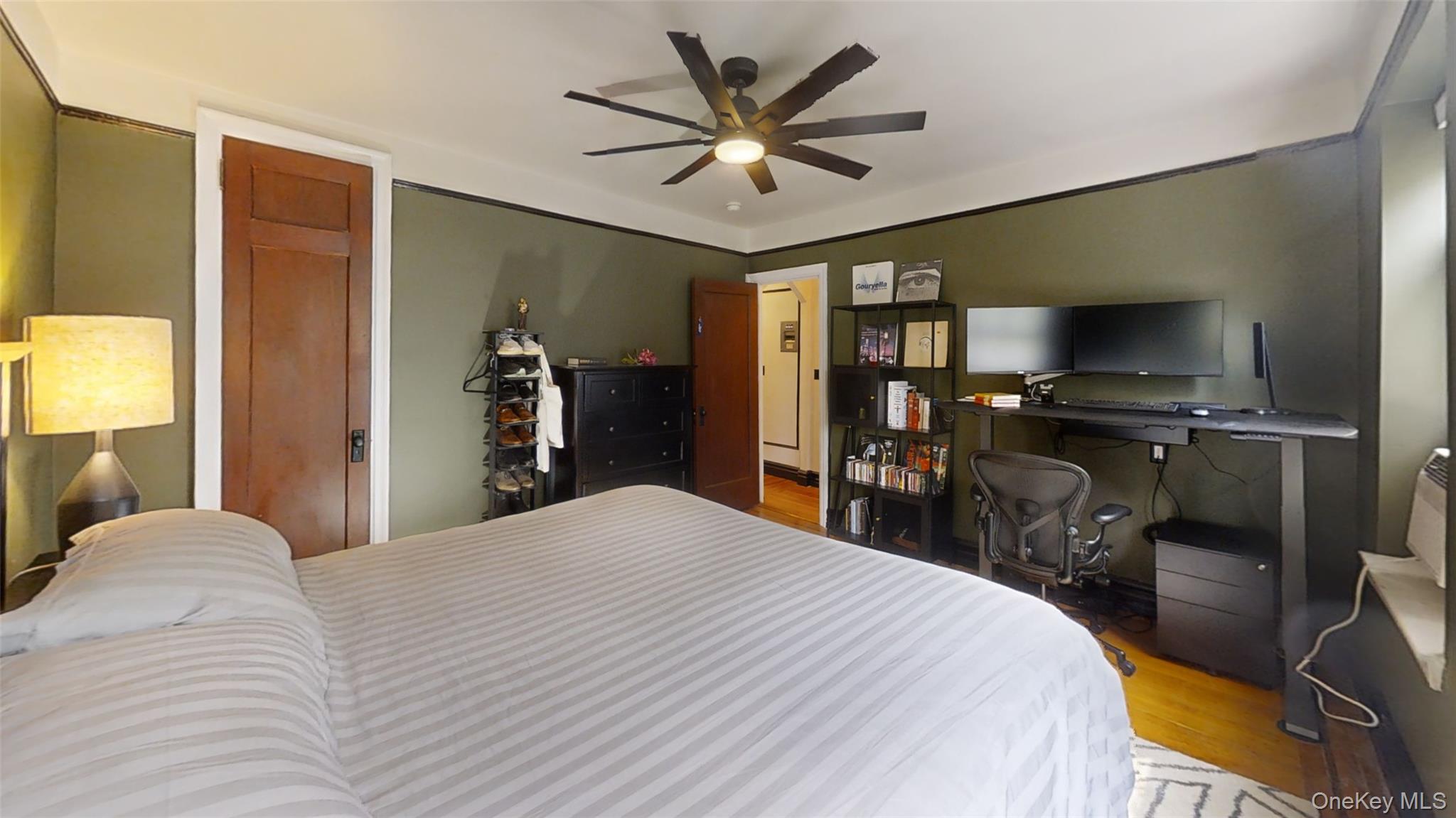 105 Garth Road, Unit 4K Scarsdale, NY 10583 - Photo 3 of 6 a bedroom with a bed and a flat tv screen on dresser