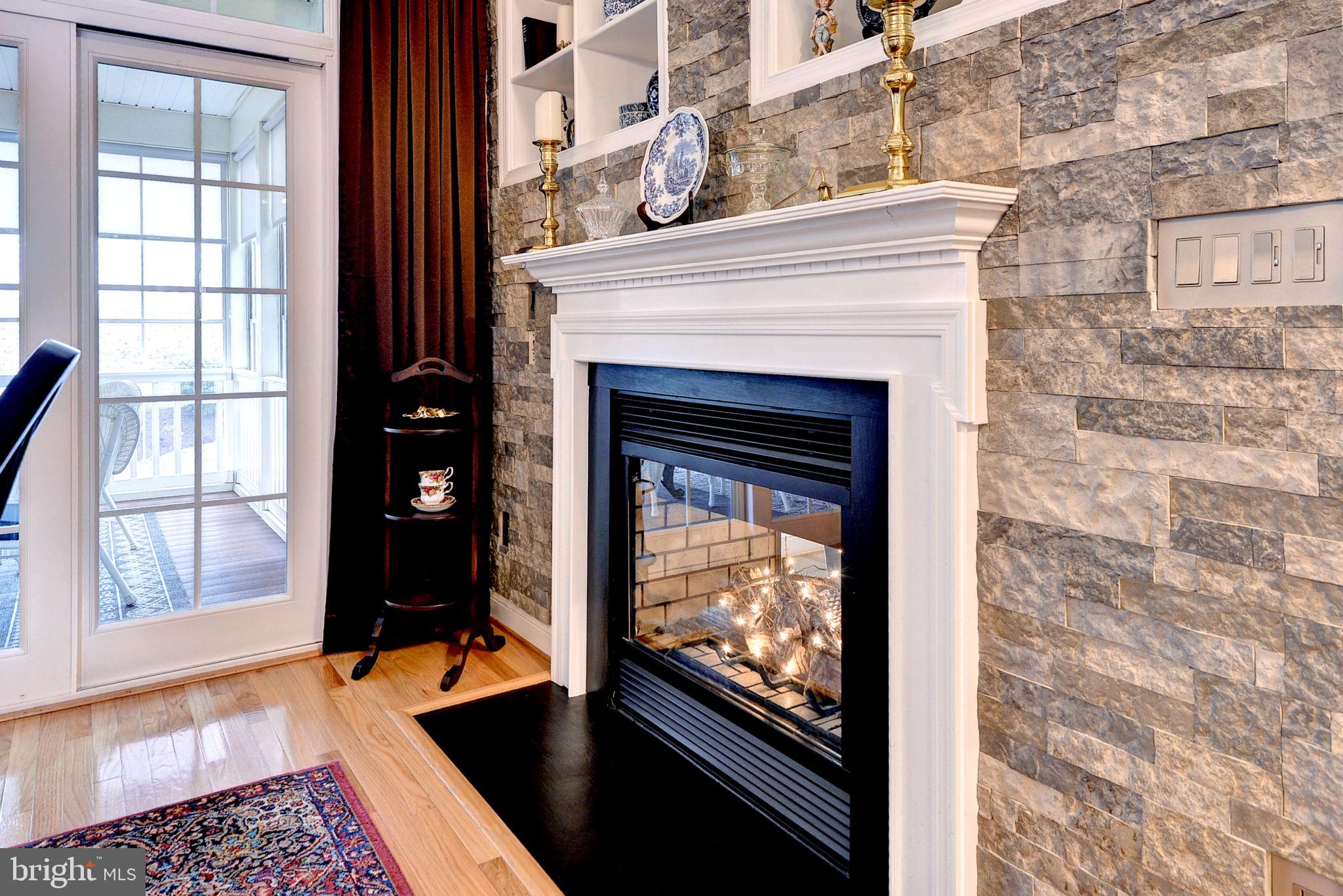 7100 Pinebrook Road Williamsburg, VA 23188 - Photo 17 of 86 a living room with a fireplace and a floor to ceiling window