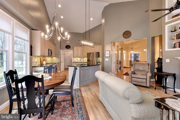a kitchen with granite countertop a stove a sink and a dining table