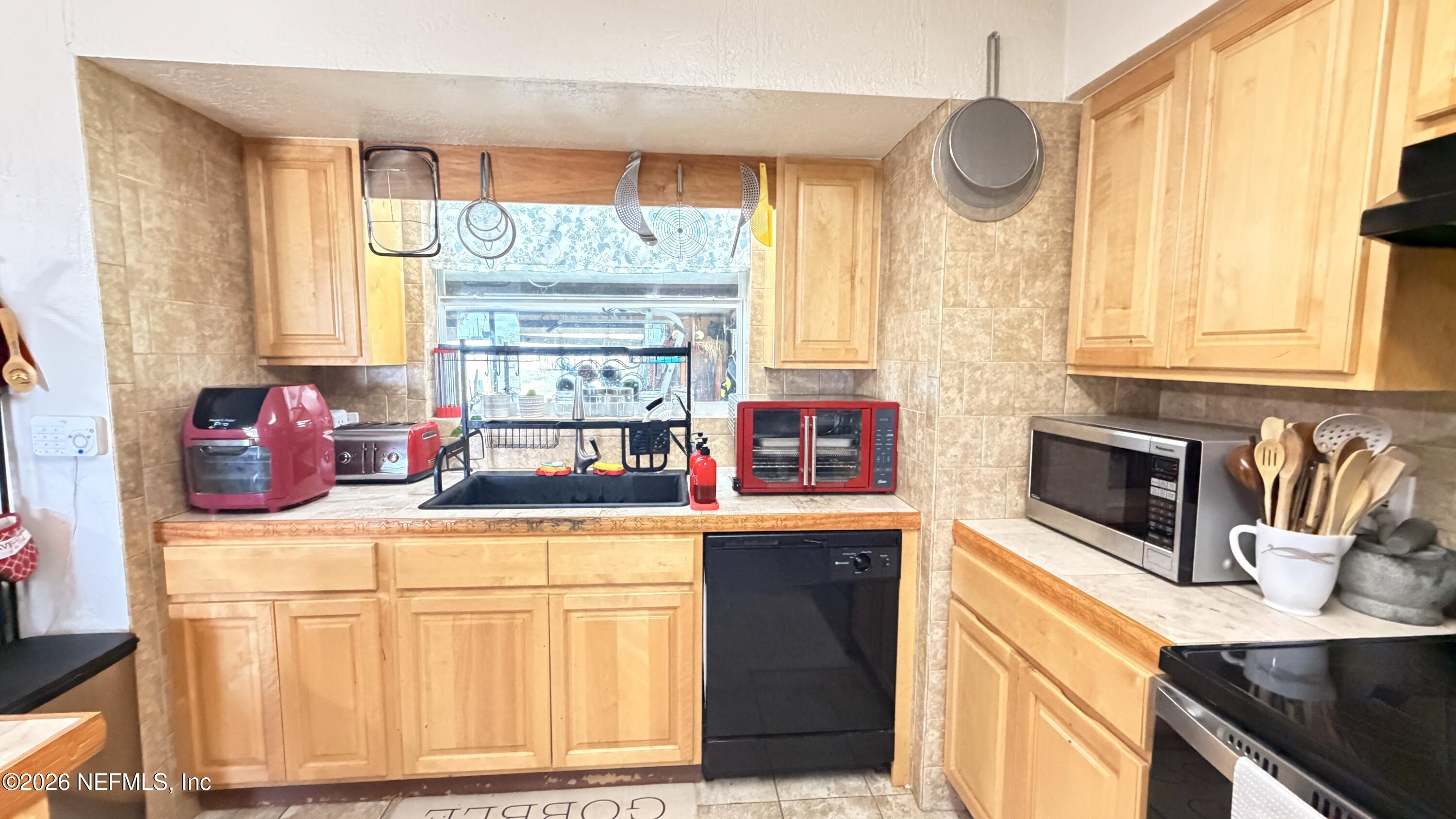 1302 Fort Meade Road Frostproof, FL 33843 - Photo 27 of 39 a kitchen with granite countertop a stove a sink and a window