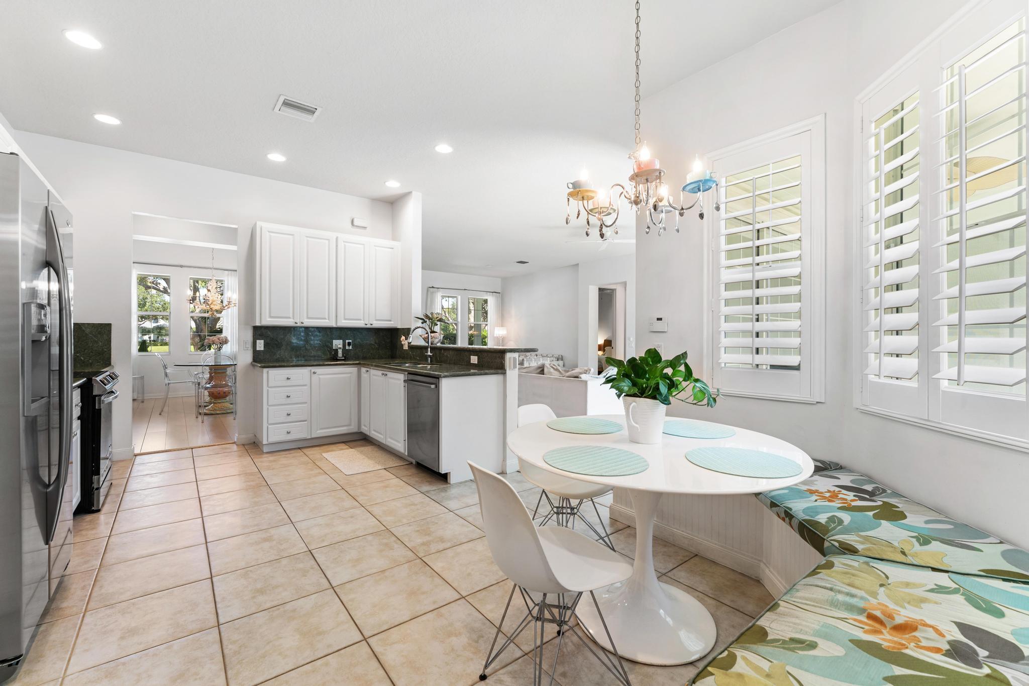 3446 West Mallory Boulevard Jupiter, FL 33458 - Photo 18 of 56 a kitchen with stainless steel appliances granite countertop a stove a sink and a refrigerator