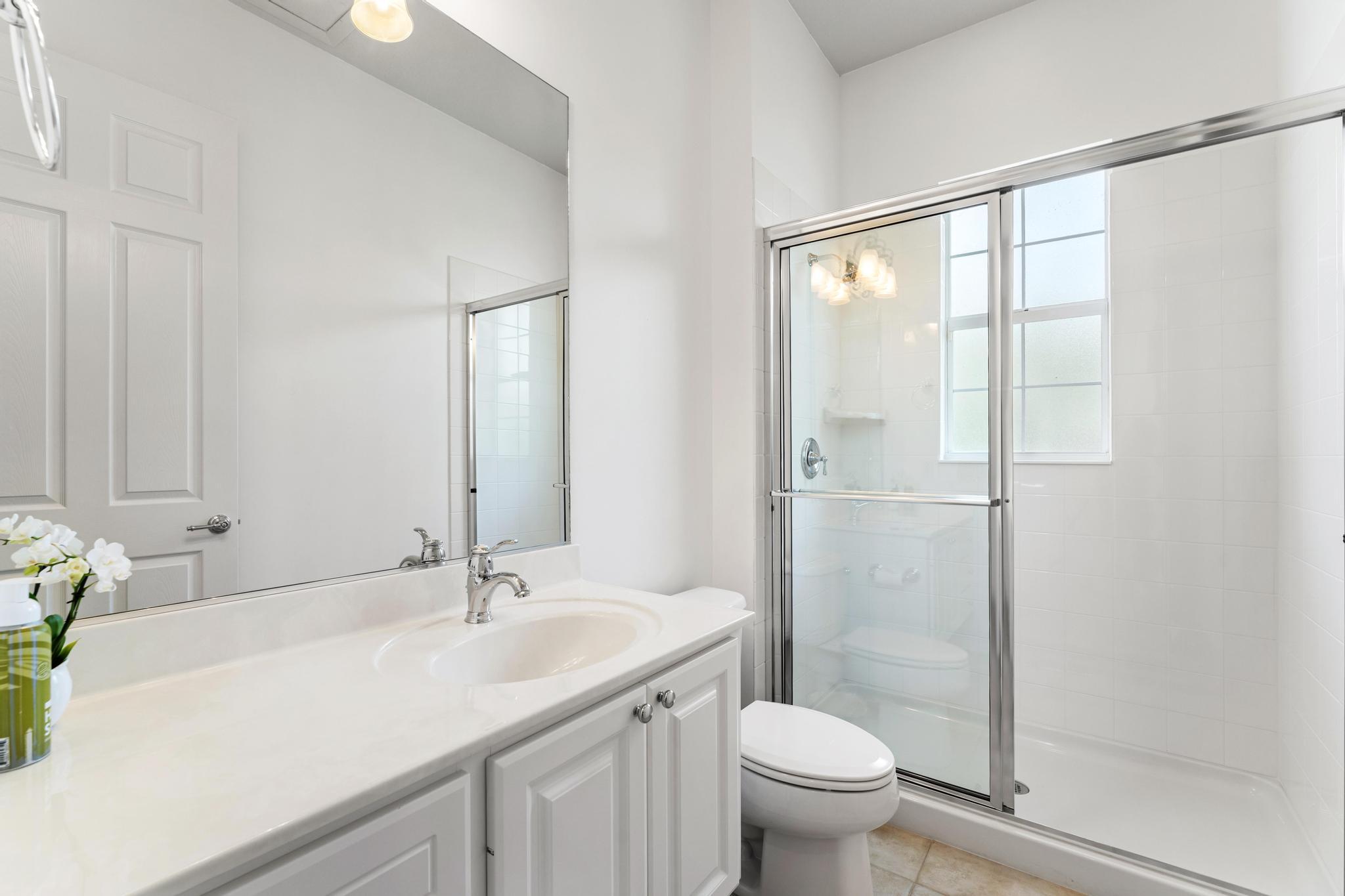 3446 West Mallory Boulevard Jupiter, FL 33458 - Photo 35 of 56 a bathroom with a granite countertop sink toilet and shower