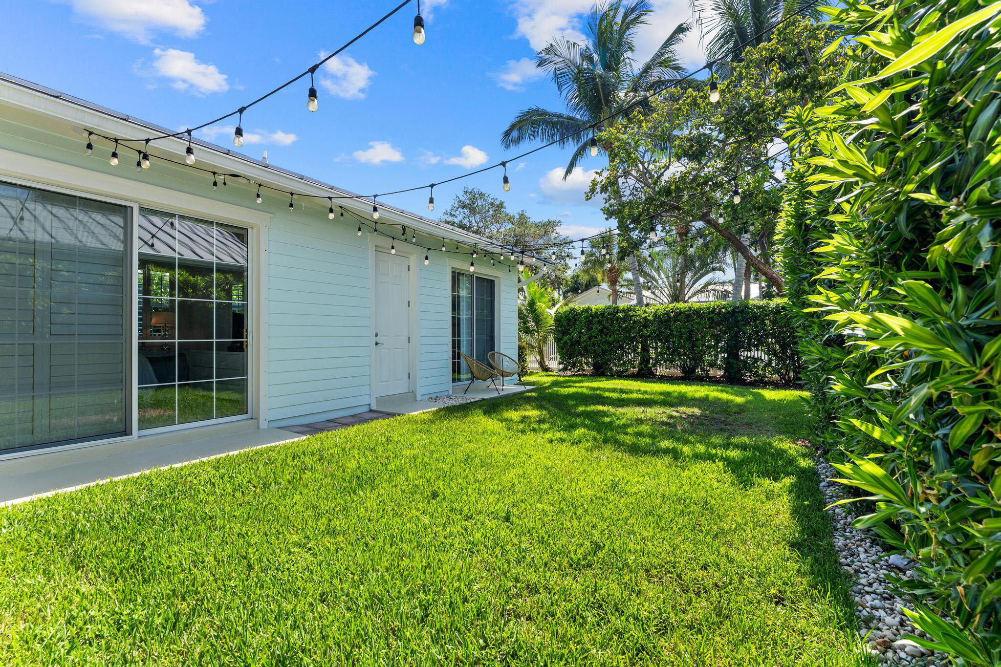 3446 West Mallory Boulevard Jupiter, FL 33458 - Photo 38 of 56 a view of a backyard with large trees and a small yard