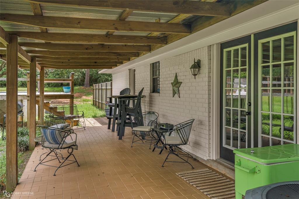 1426 Caney Lake Road Minden, LA 71055 - Photo 25 of 36 Covered patio featuring a brick-style tiled surface and a wood-beamed roof structure