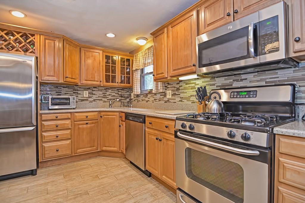 45 Frank Road Stoughton, MA 02072 - Photo 5 of 41 a kitchen with stainless steel appliances granite countertop a stove a sink and a microwave