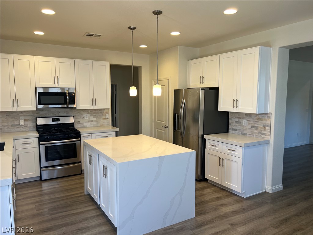 9581 Aberdeen Ridge Court Las Vegas, NV 89148 - Photo 7 of 25 A chef's kitchen features stainless steel appliances and a center island, perfect for culinary endeavors.